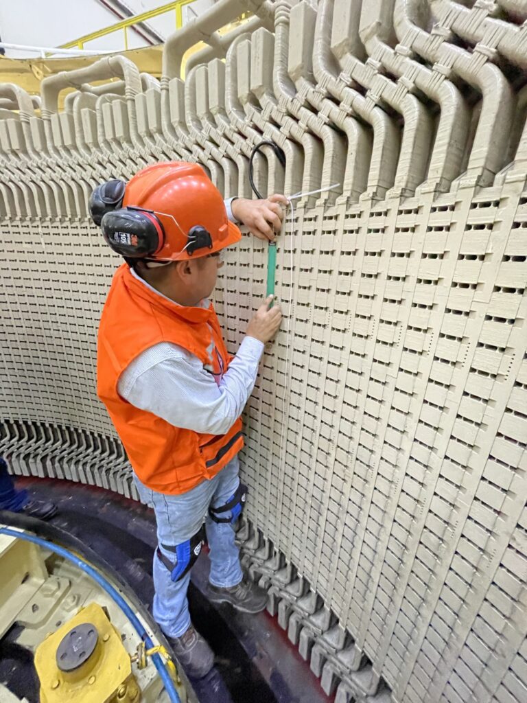 Technician installing an air gap sensor on the stator core laminations, ensuring precise positioning for accurate measurements.